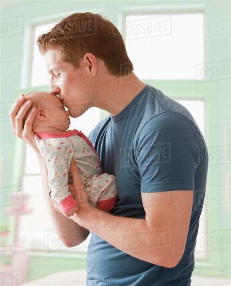 Caucasian father kissing baby girl - Stock Photo - Dissolve