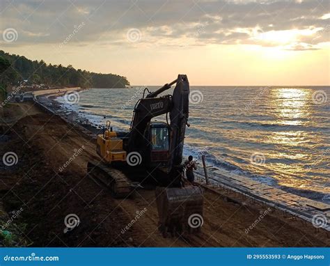 Excavator at Sea Wave Barrier Construction Project on Beach at Sunset ...