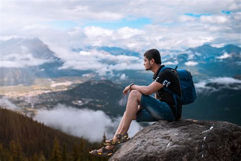 Young man sitting on the cliff of the mountain - PixaHive