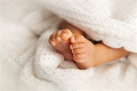 Newborn baby feet under blanket | People Images ~ Creative Market