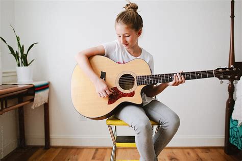 "Young Girl Playing Guitar" by Stocksy Contributor "Erin Drago" - Stocksy