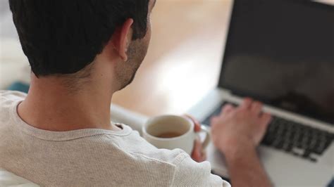 Man drinking coffee while using laptop 1406711 Stock Video at Vecteezy