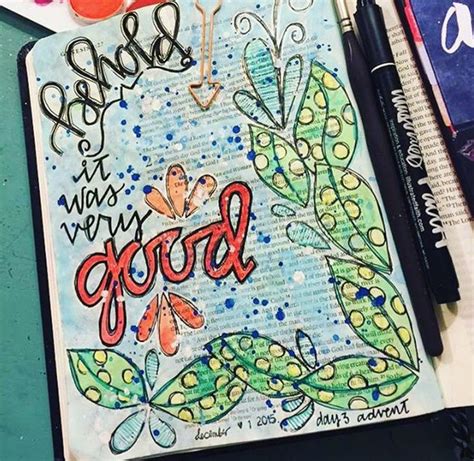 an art journal with writing and doodles on the cover, surrounded by other arts and crafts supplies