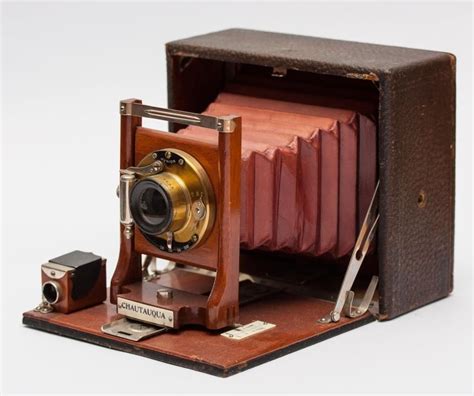 an old fashioned camera sitting on top of a wooden box