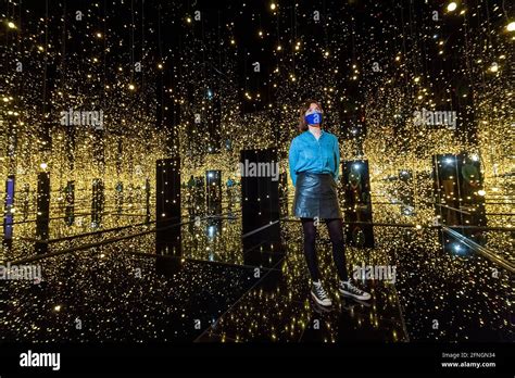 London, UK. 17 May 2021.A Tate staff member views "Infinity Mirrored Room – Filled with the ...