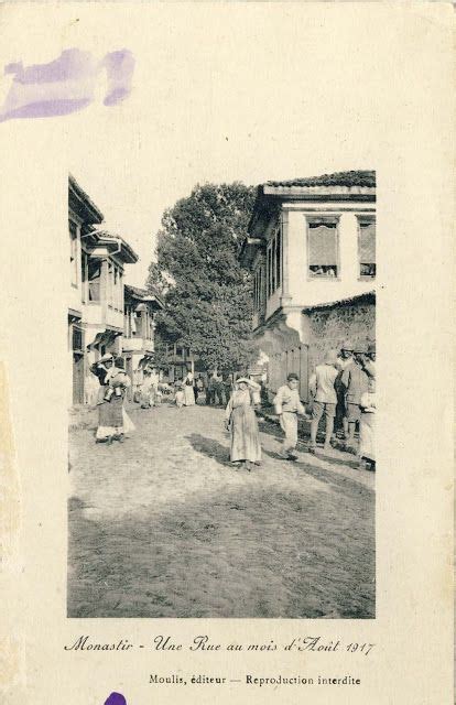 an old black and white photo of people walking down the street in front of houses