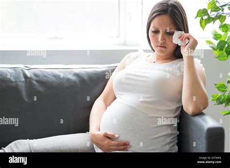 Sad pregnant woman lying on sofa at home Stock Photo - Alamy