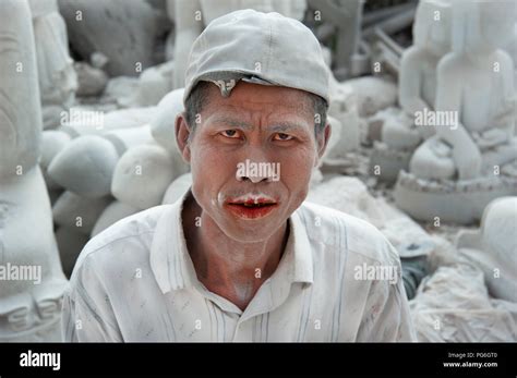Portrait of a Burmese marble carver with his face covered in white marble dust in Mandalay ...