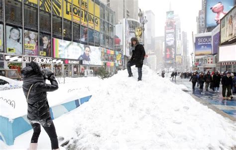 Photo: A Man has his photo taken on a mound of snow in Times Square ...