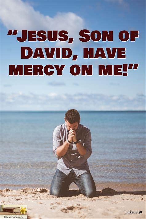 a man kneeling down in the sand with his hand on his face