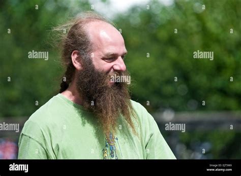 A man sports a long straggly beard and a ponytail Stock Photo - Alamy