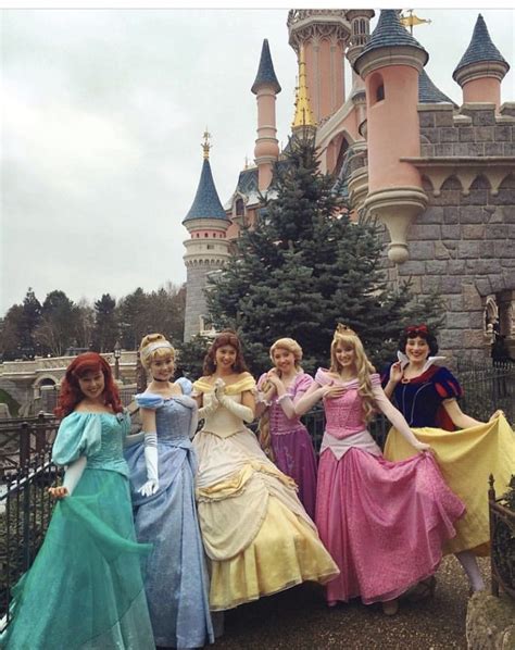 four women dressed in princess dresses posing for a photo with the ...