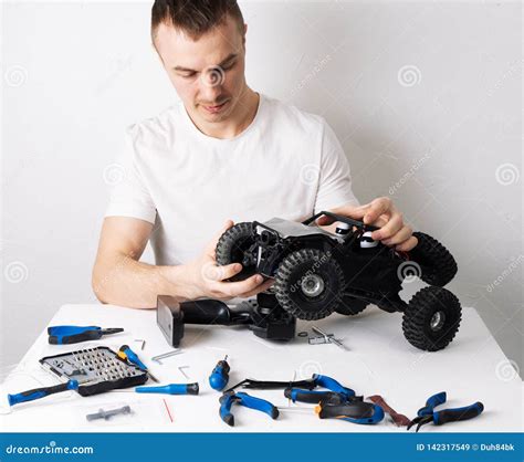 Man Repairing a Radio-controlled Model Car Buggy. on the Table are ...