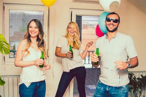 Free Photo | Friends laughing at party with bottle of beer