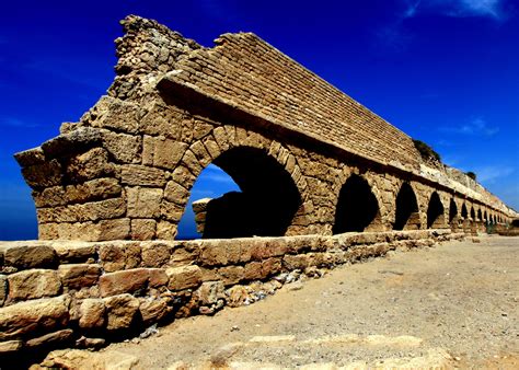 an old brick structure with arches on the side and blue sky in the back ...