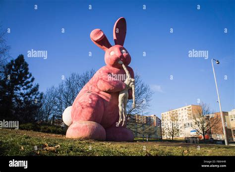 giant pink rabbit eating a headless human body statue Stock Photo - Alamy