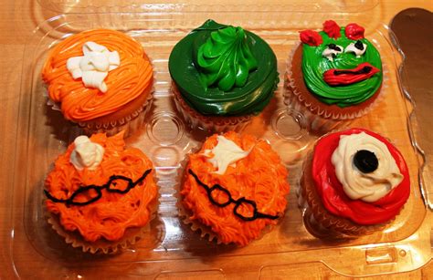 six cupcakes decorated in different colors and designs on a plastic tray with forks