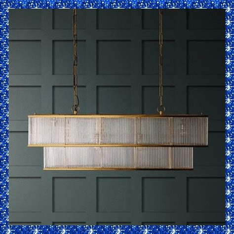 a large rectangular light fixture hanging from a metal chain in a room ...