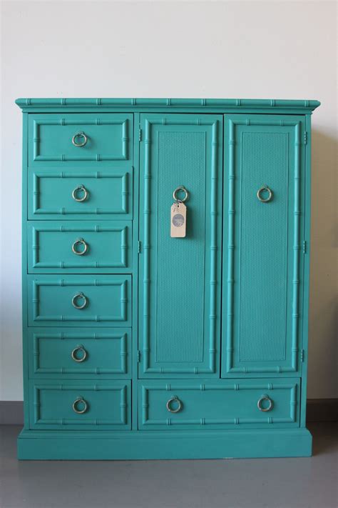 an armoire with drawers painted teal