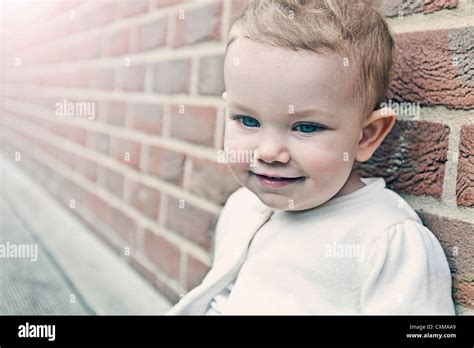 Beautiful Baby Girl against Brick Wall Stock Photo - Alamy