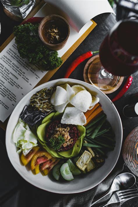 Healthy salad bowl served with sauce and glass of wine in cozy cafe · Free Stock Photo