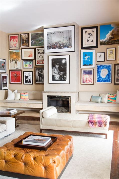 An eclectic and well-varied gallery wall adds colorful depth to a sleek, contemporary neutral ...