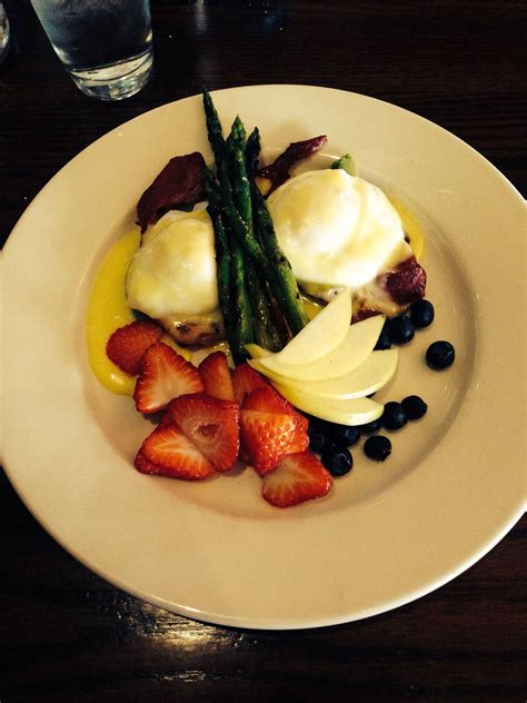 a white plate topped with fruit and veggies on top of a wooden table