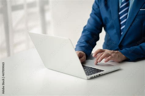 Person typing on laptop keyboard, businessman working on laptop, he is typing messages to ...