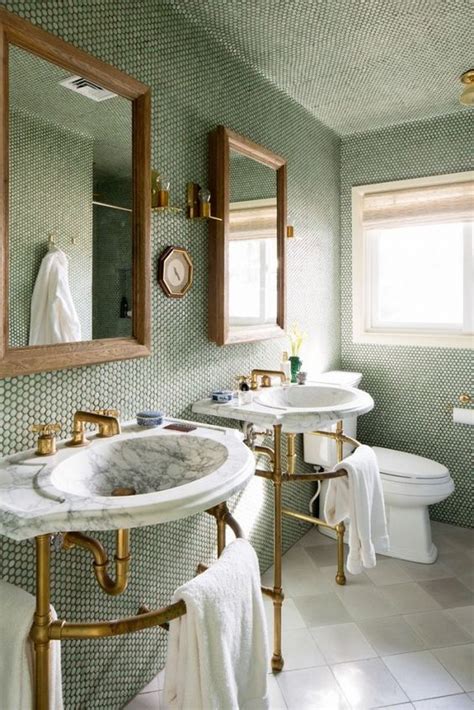 bathroom with brass and marble fixtures and a wall of moss green penny ...