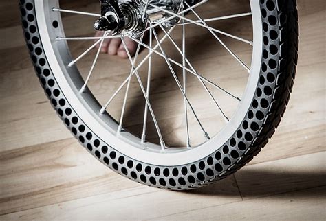 a close up of a bike tire on a wooden floor with someone's hand touching the spokes