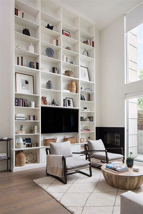 Dramatic tall white bookcase with a built-in tv in this modern living ...