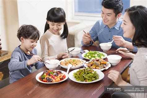 Chinese family eating at dining table together — Chinese culture, dinner - Stock Photo | #184811494