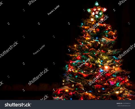 Snow Covered Christmas Tree With Multi Colored Lights At Night Stock ...