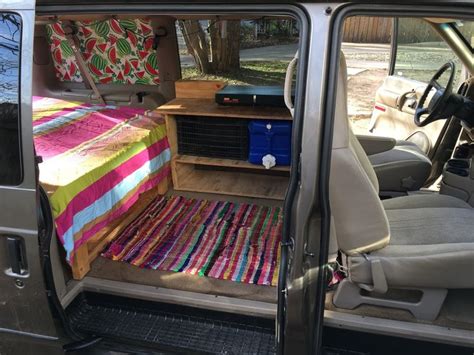 the back end of a van with a bed in it