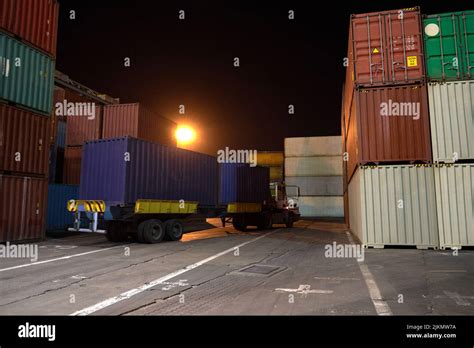 operation of container terminal at night. Unloading container ship at night. Mooring cranes ...