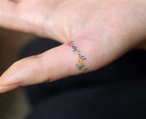 Floral ring tattoo on a thumb - Tattoogrid.net