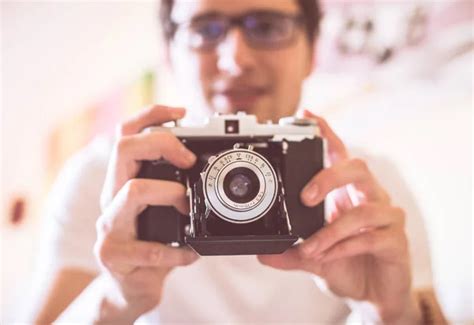 man with a vintage camera on background,close up - Stock Image - Everypixel