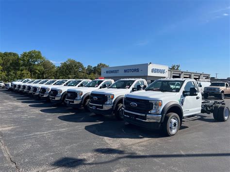 a row of trucks parked next to each other in front of a building on a parking lot