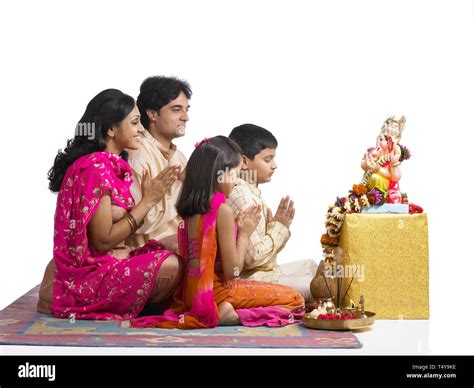 INDIAN FAMILY OF 4 performing puja TO LORD GANAPATI Stock Photo - Alamy