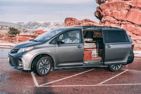 a silver van parked in front of a mountain