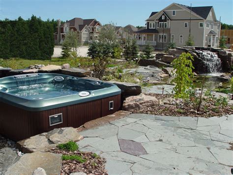 Hot tub installed partially in ground with lots of stonework and ...