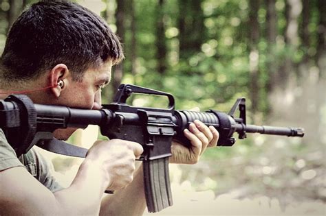 Premium Photo | Man shooting with rifle in forest