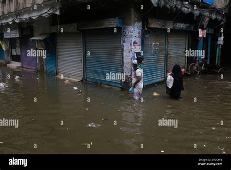 DHAKA, BANGLADESH- AUGUST 7, 2023: Residents walk through flooded ...