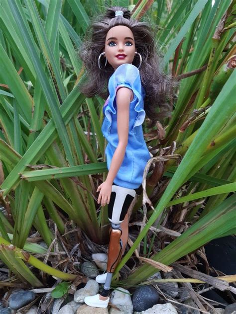 a doll is standing in the middle of some plants