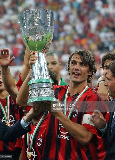 AC Milan captain Paolo Maldini (C) holds the trophy in celebration after winning the Italian ...