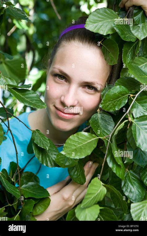Portrait of a young woman's face framed by leaves Stock Photo - Alamy