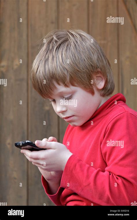 young boy writing a text message on a mobile phone Stock Photo - Alamy