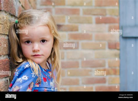 Portrait of girl leaning against brick wall Stock Photo - Alamy