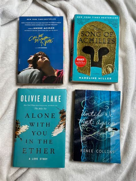 four books are laid out on a bed