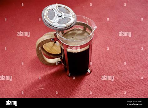 Delicious arabica coffee made by french press technique standing on red background with ...